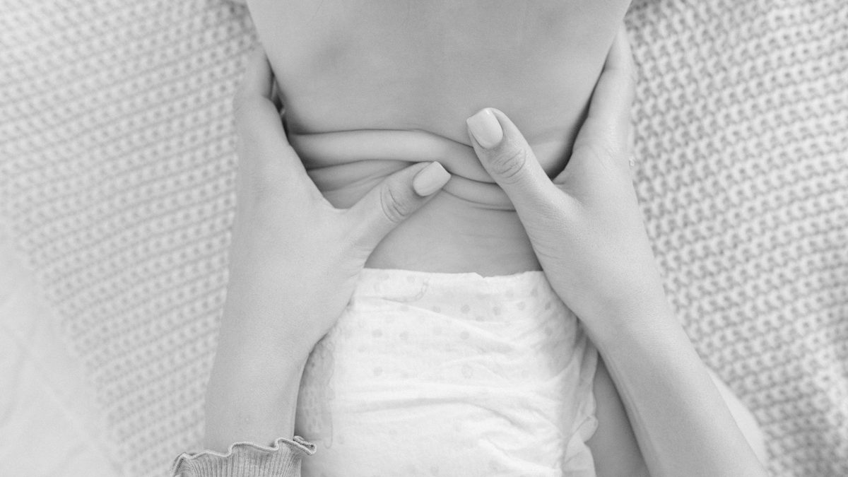 Mains d'ostéopathe posées avec douceur sur le buste d'un nourrisson